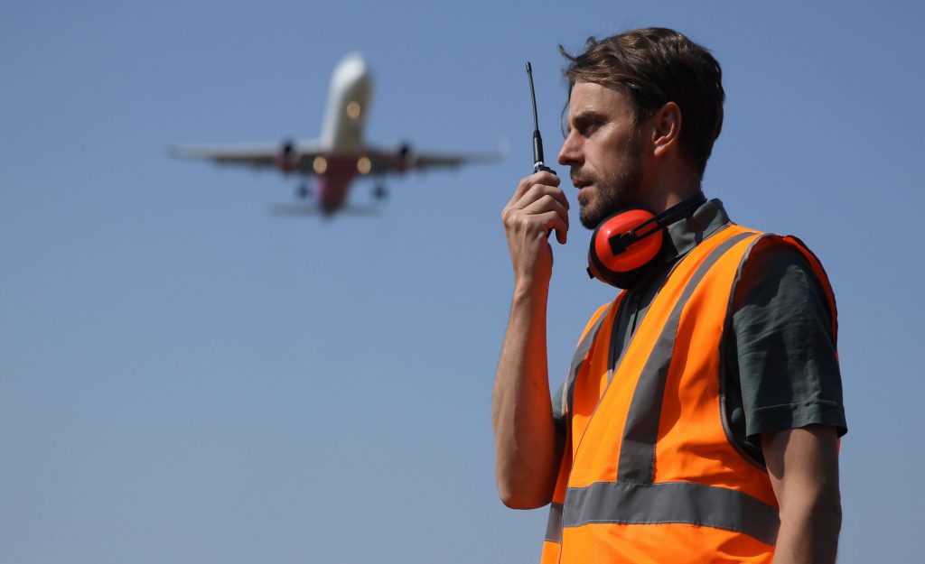 Airport Ground Worker Man Communicating Over Walkie Talkie with